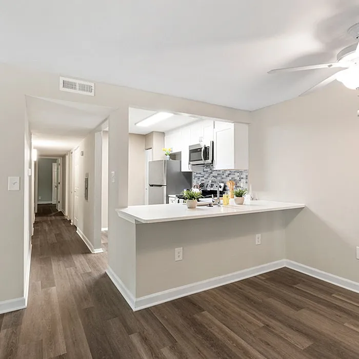 Modern apartment kitchen with sleek countertops, stylish backsplash, and elegant wood flooring.