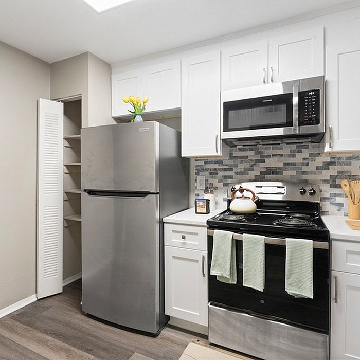 Modern kitchen with stainless steel appliances, sleek cabinetry, and elegant backsplash, ideal for culinary creativity.