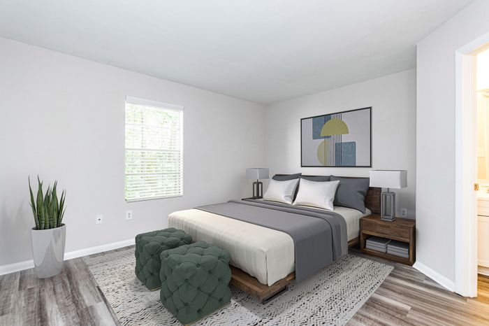 Spacious room with elegant dark wood flooring and soft neutral walls, enhanced by a ceiling fan for comfort.