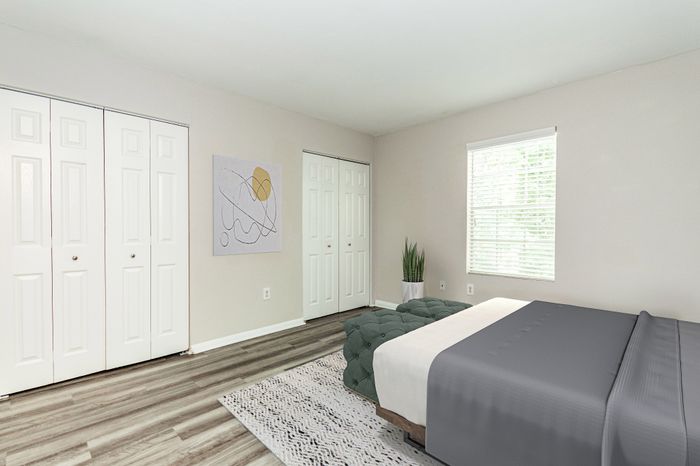 Spacious room with elegant dark wood flooring and soft neutral walls, enhanced by a ceiling fan for comfort.