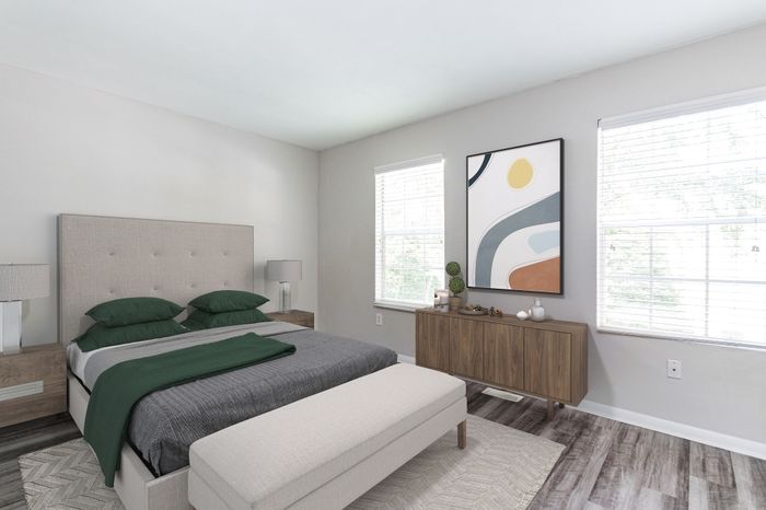 Spacious room with elegant dark wood flooring and soft neutral walls, enhanced by a ceiling fan for comfort.
