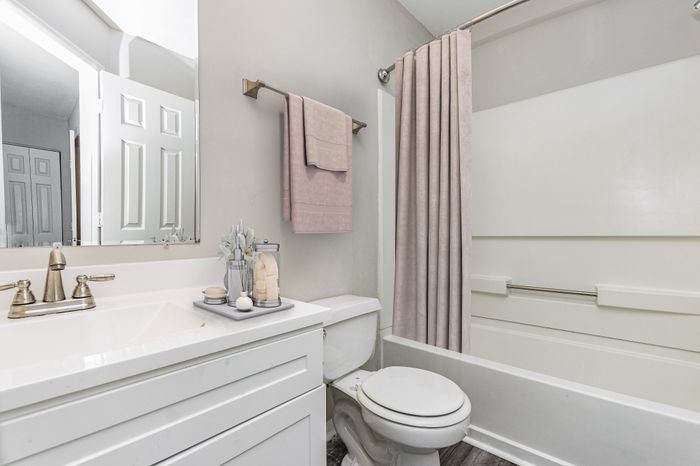 Modern bathroom with sleek white fixtures, elegant vanity, and bright lighting, offering a fresh and inviting atmosphere.