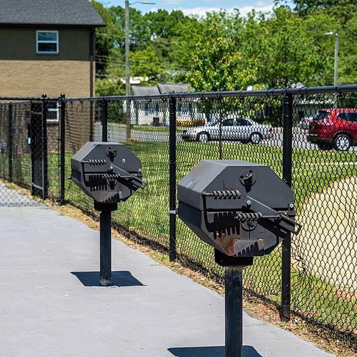 Inviting outdoor space with modern barbecue grills and a scenic fenced backdrop, ideal for entertaining.