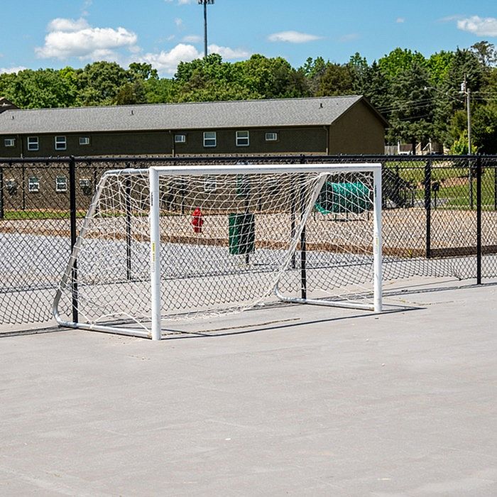 Inviting recreational area with a sports field and goalpost, perfect for outdoor activities in a sunny community setting.