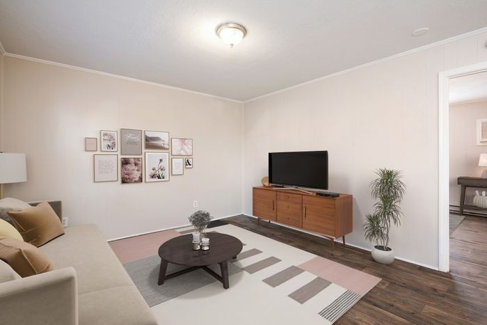Inviting living room with cozy sofa, elegant wall art, modern TV console, and stylish coffee table, perfect for relaxation.
