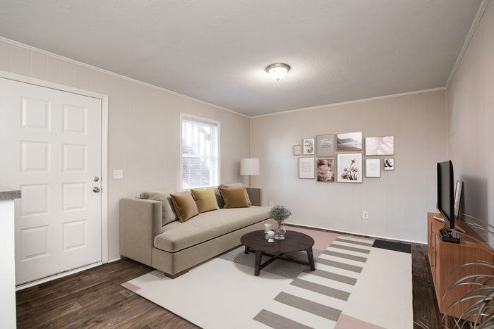 Modern living room with stylish beige sofa, elegant wall art, and cozy atmosphere.
