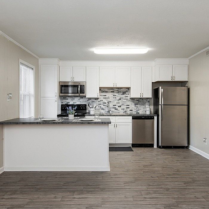 Modern kitchen with sleek stainless steel appliances, elegant white cabinetry, and stylish tile backsplash.