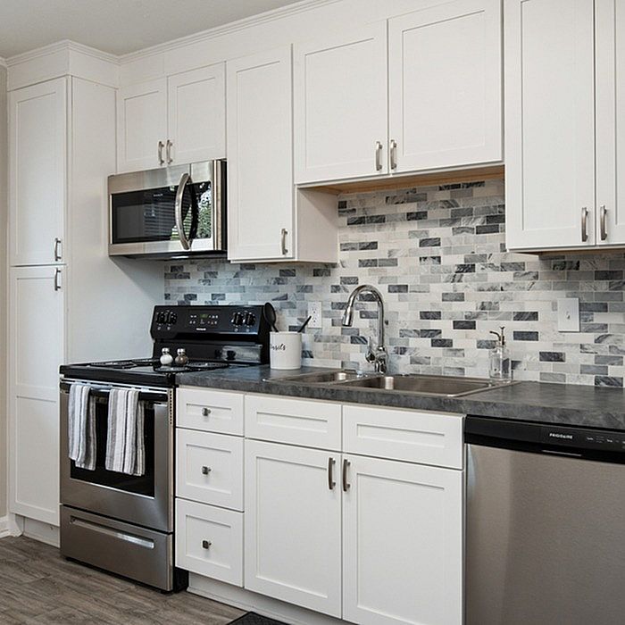 Modern kitchen with sleek stainless steel appliances, elegant white cabinetry, and stylish subway tile backsplash.