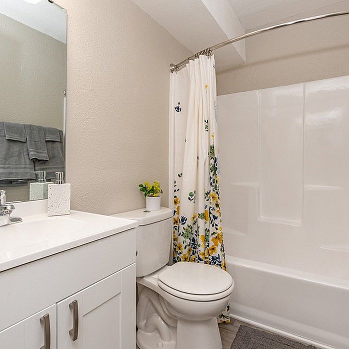 Inviting bathroom with modern vanity, floral shower curtain, and elegant decor.