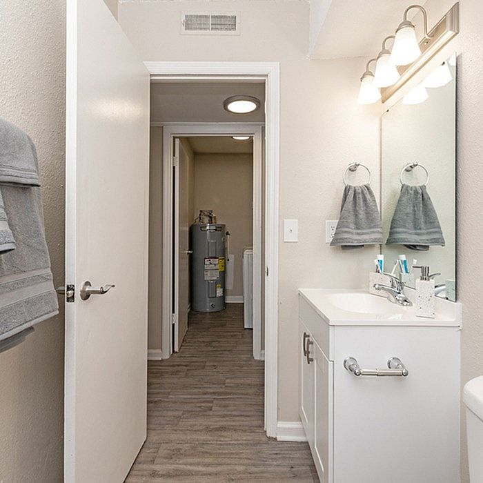 Bright and modern bathroom with sleek vanity, elegant lighting, and convenient laundry access.
