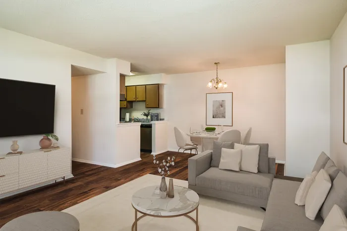 Elegant open-plan living and dining area with chic decor, cozy sofa, and modern kitchen in a bright, inviting space.
