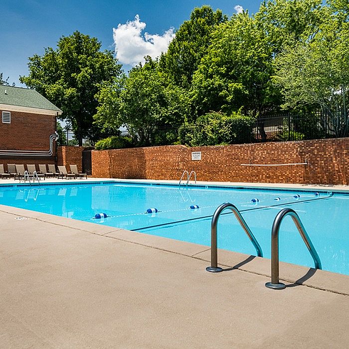 Inviting outdoor pool area surrounded by lush greenery and comfortable lounge chairs, perfect for relaxation and leisure.