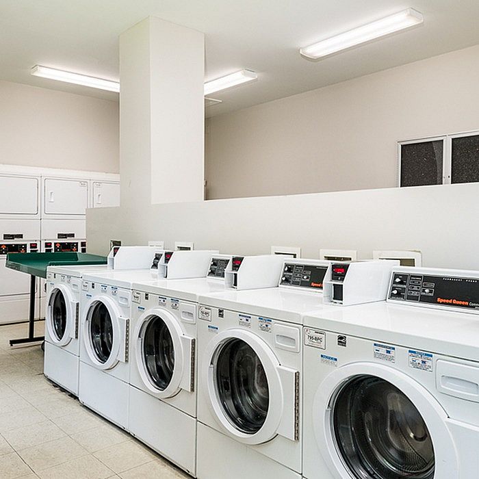 Modern laundry room with multiple industrial-grade washers and dryers, exemplifying convenience and efficiency in a bright, clean environment.