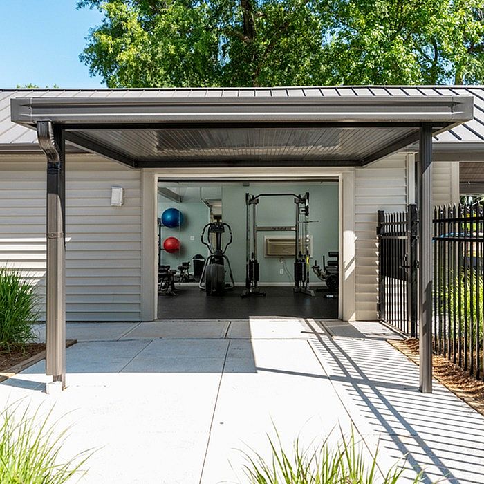Modern outdoor gym facility with state-of-the-art equipment and vibrant exercise setup, surrounded by lush greenery.