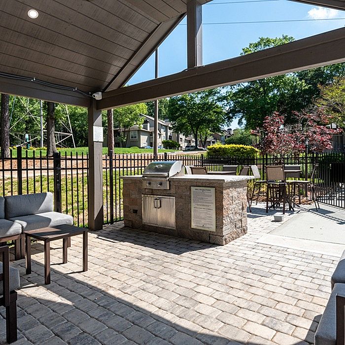 Charming outdoor patio with a stylish barbecue area, comfortable seating, and lush green surroundings for perfect relaxation.