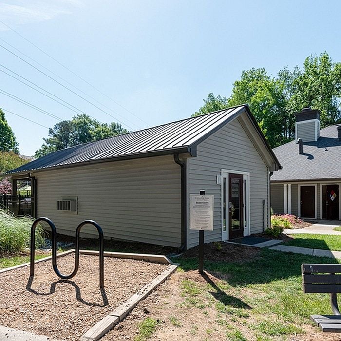 Charming outdoor view of a modern community building with sleek siding, surrounded by lush greenery and open blue skies.