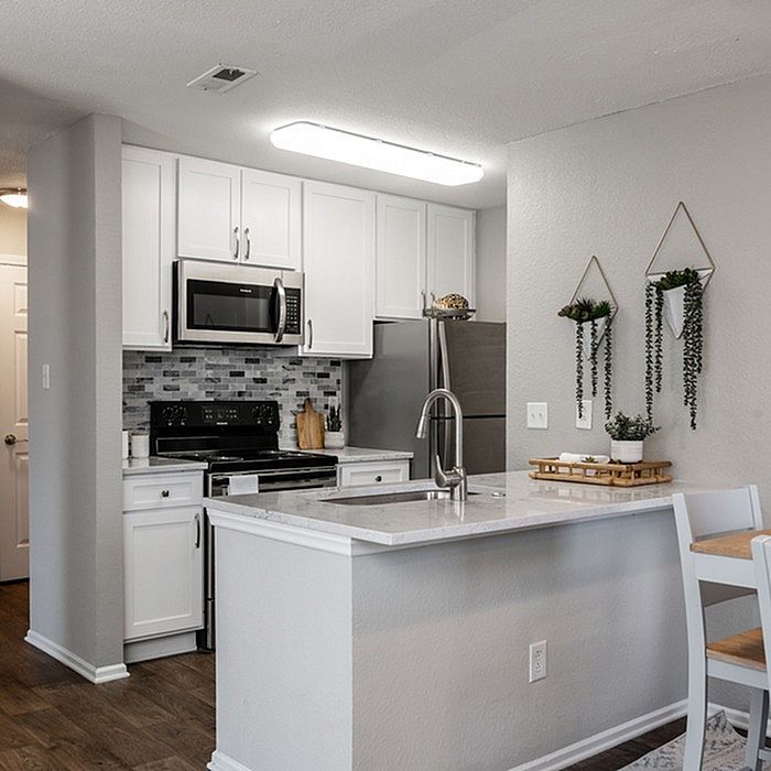 Modern kitchen with sleek stainless steel appliances, elegant marble countertop, and stylish tile backsplash.