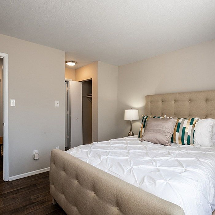Bright and cozy bedroom with modern decor, featuring a plush bed, elegant pillows, and sleek wooden flooring.
