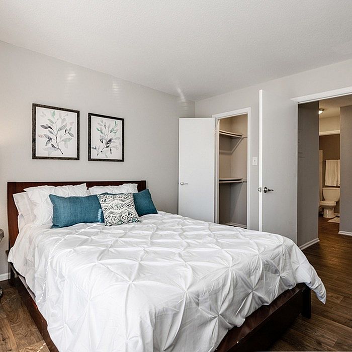 Elegant bedroom with plush bedding, modern decor, and spacious walk-in closet.