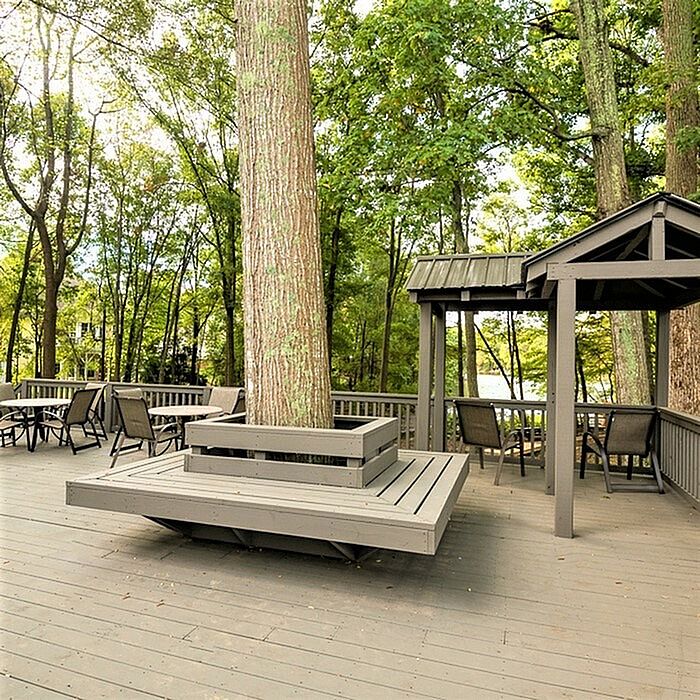 Stunning outdoor patio with modern seating, nestled among lush trees, offering serene nature views.