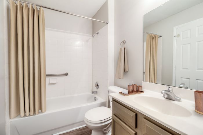 Elegant bathroom featuring a modern sink, sleek faucet, and a pristine shower area with neutral decor accents.