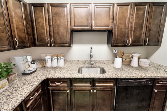 Modern kitchen with elegant wooden cabinets, sleek granite countertops, and high-end appliances, perfect for culinary enthusiasts.