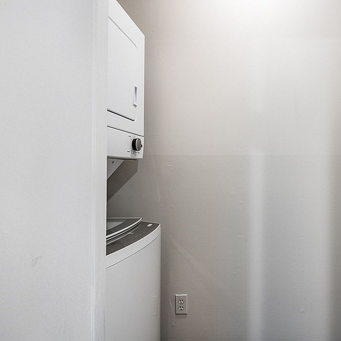 Compact laundry area with sleek stacked washer and dryer in a modern apartment.