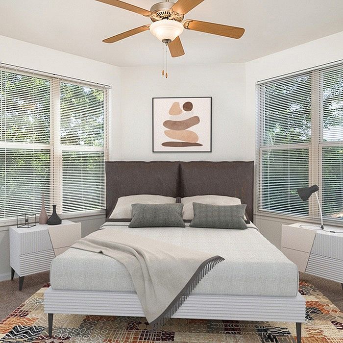 Chic bedroom with modern decor, natural light streaming through large windows, and cozy, inviting bedding.