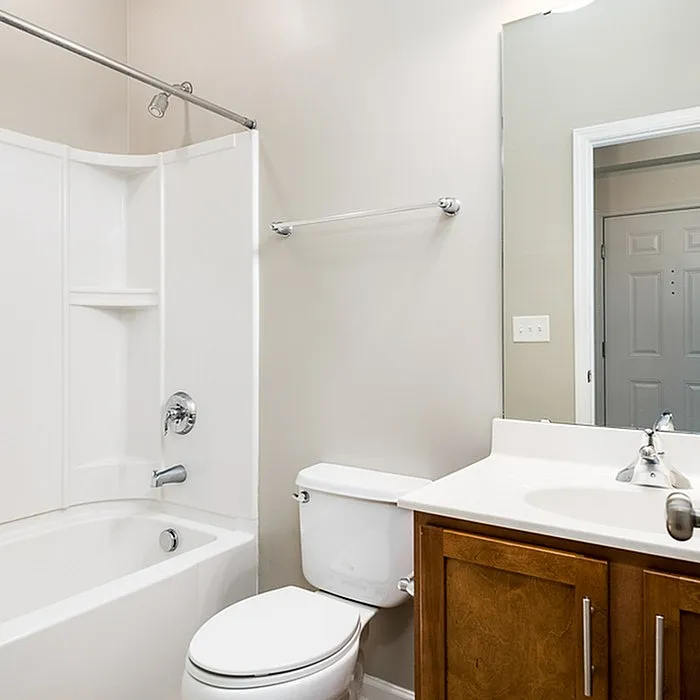 Modern bathroom featuring sleek fixtures, a cozy bathtub, and elegant wooden cabinetry perfect for relaxation.