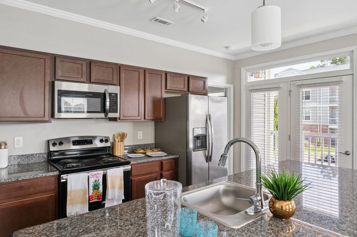Elegant kitchen with stainless steel appliances, granite countertops, and large windows for natural light.