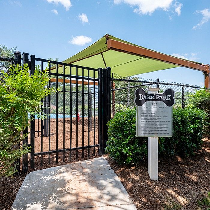 Inviting pet-friendly Bark Park with shaded area, ideal for outdoor fun and relaxation for dogs.