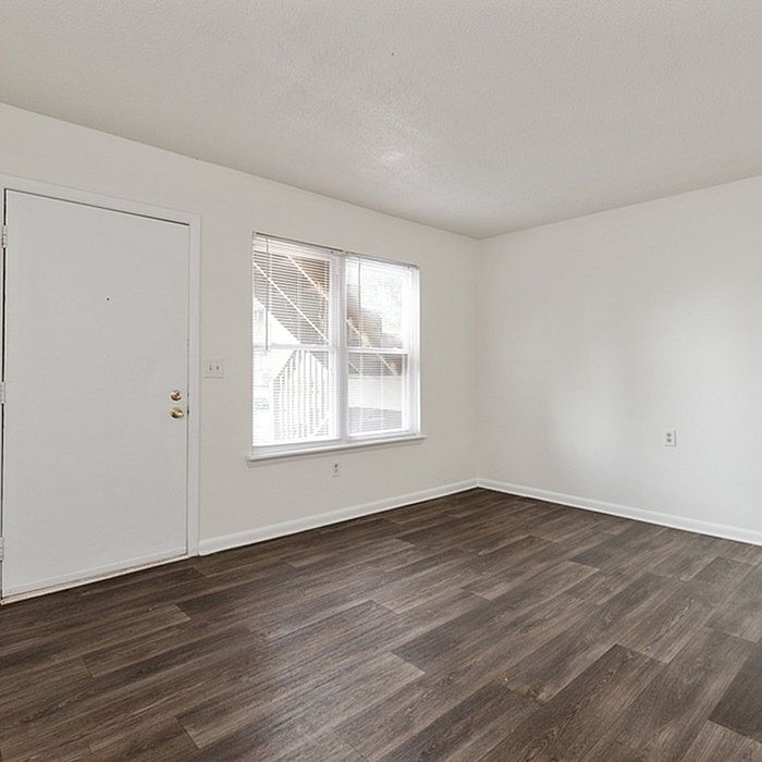 Bright and inviting room with elegant hardwood flooring and large windows offering natural light.