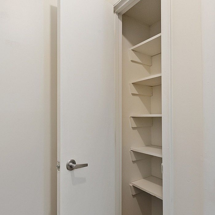 Sleek apartment closet with ample shelving space for organized storage.