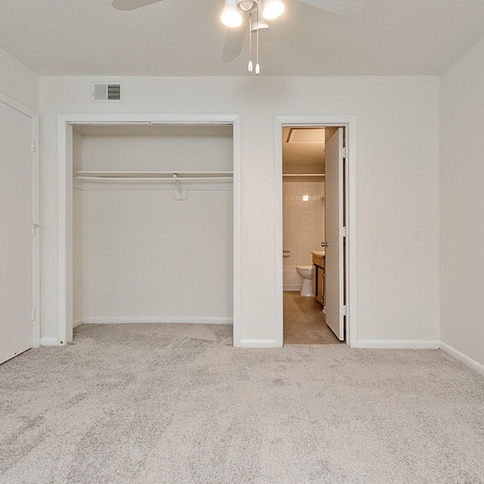 Inviting bedroom with plush carpeting, spacious closet, and modern ensuite bathroom.