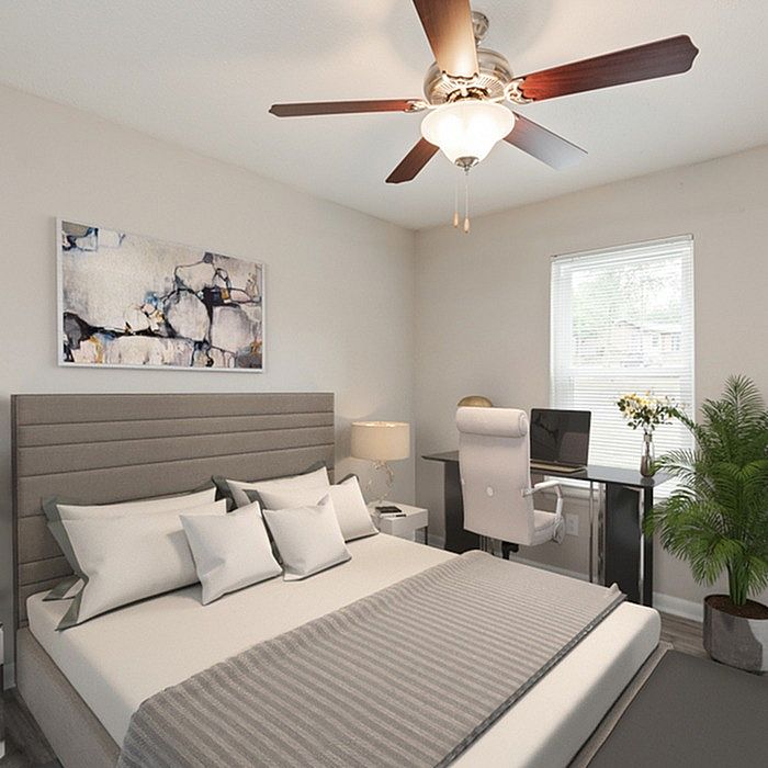 Contemporary bedroom design featuring a stylish ceiling fan, cozy bed with plush pillows, chic artwork, desk with modern chair, and vibrant indoor plant.