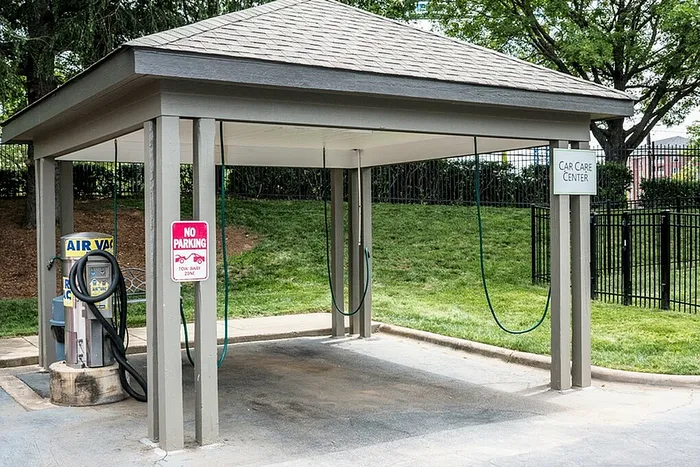 Modern car care center with air vacuum surrounded by lush greenery, offering convenient and efficient vehicle maintenance.
