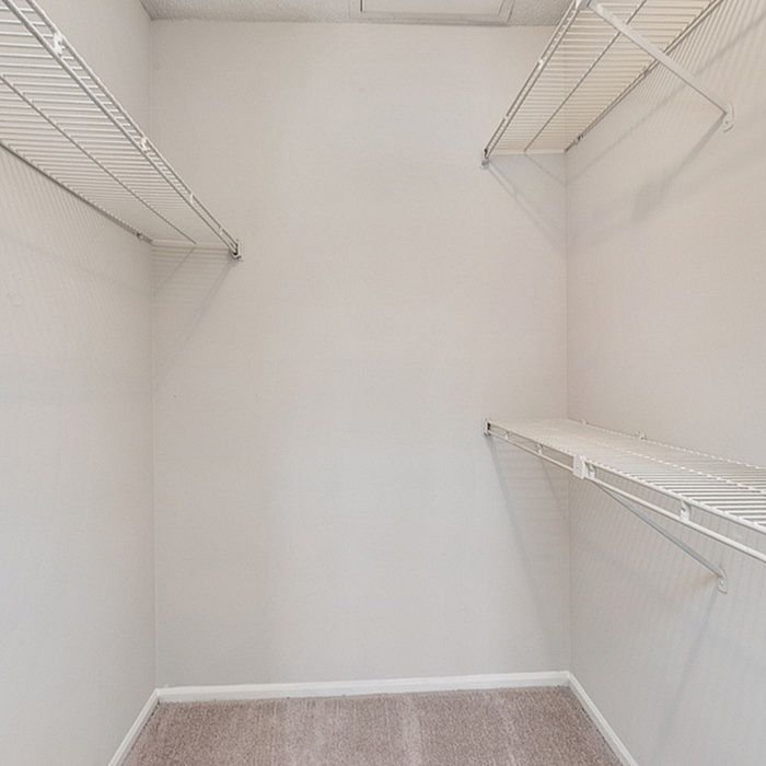 Spacious walk-in closet with ample shelving, offering organized storage solutions.