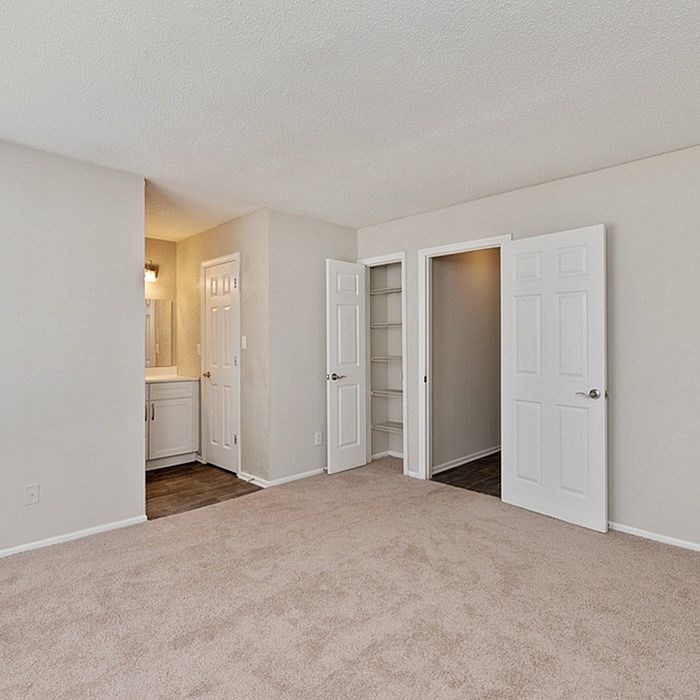 Bright, spacious bedroom with plush carpet, featuring a walk-in closet and en-suite bathroom, ideal for comfort and style.