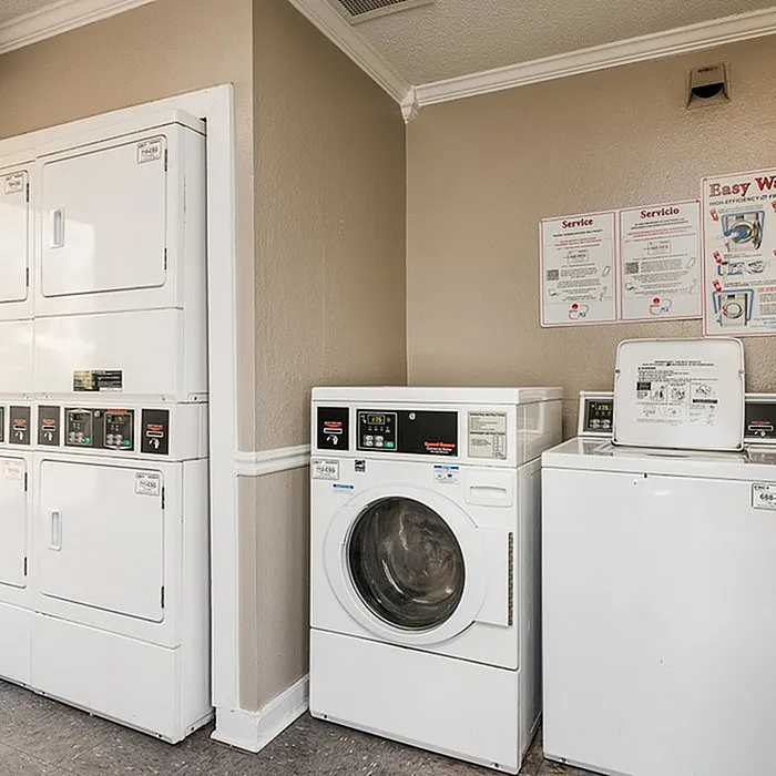 Modern laundry room with stacked dryers and washing machines, offering convenience and efficiency for residents.