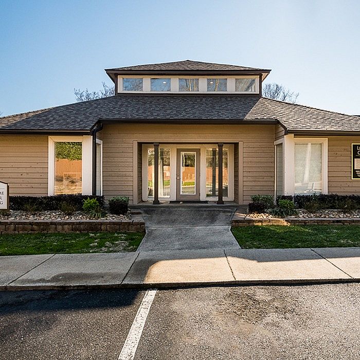 Charming entrance of a modern apartment building with a well-maintained garden and inviting pathway.
