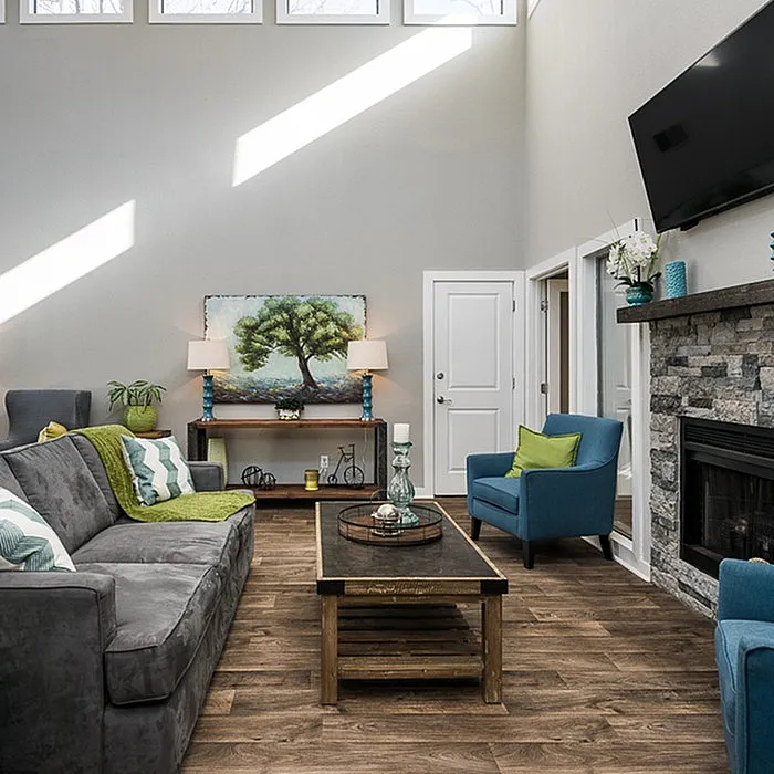 Bright, inviting living room with vaulted ceilings, elegant stone fireplace, and stylish modern furnishings.
