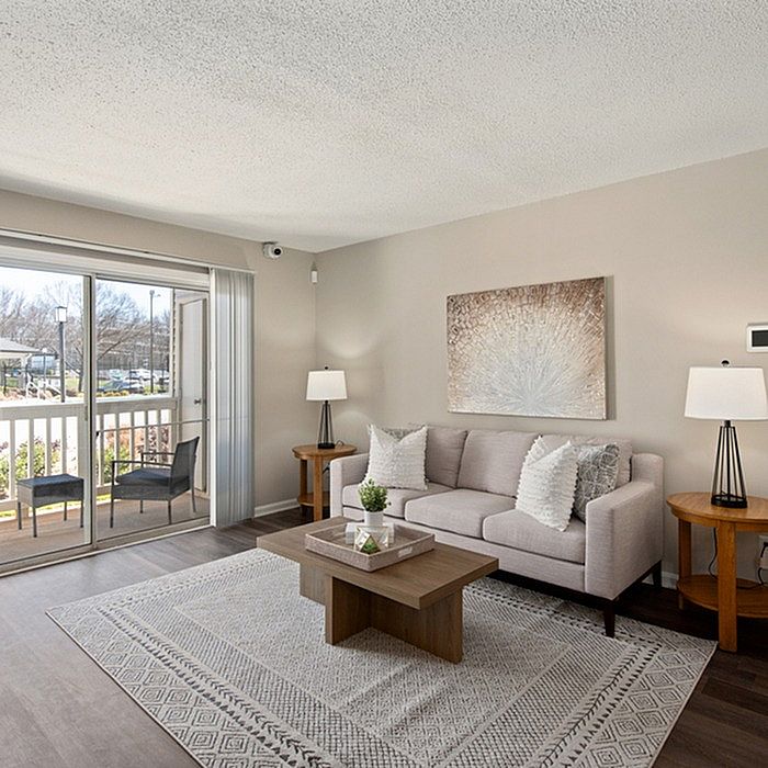 Inviting living room with a cozy sofa and elegant decor opening to a sunny balcony view.