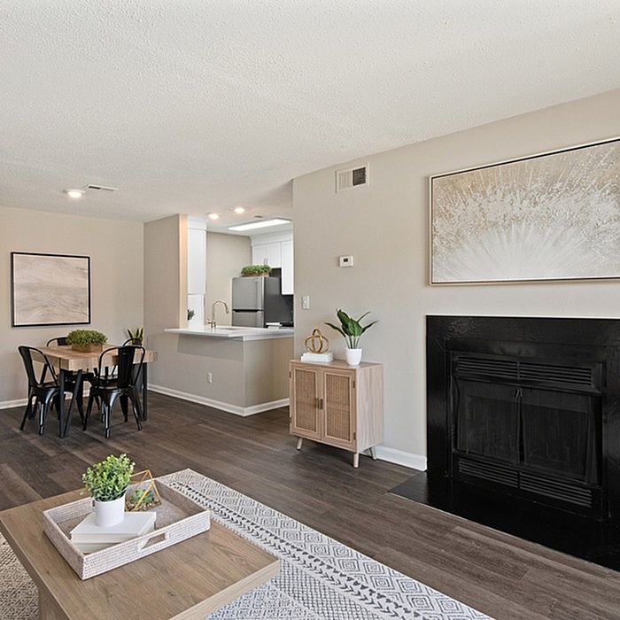 Chic open-concept living area with elegant fireplace, modern dining space, and sleek kitchen, perfect for contemporary living.