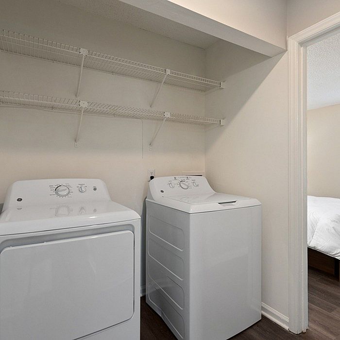 Modern laundry area featuring a sleek washer and dryer set, complemented by open shelving for effortless organization.