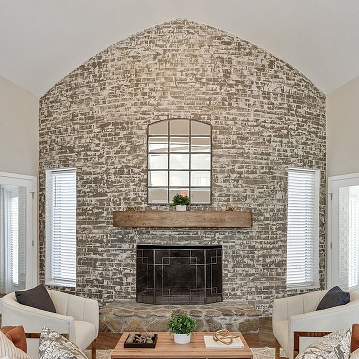Charming living room with a rustic brick accent wall, stylish fireplace, and elegant seating for cozy living.