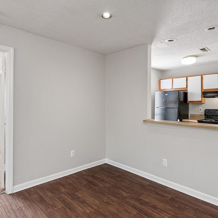Contemporary apartment with sleek hardwood floors, open kitchen with modern appliances, and ambient lighting.