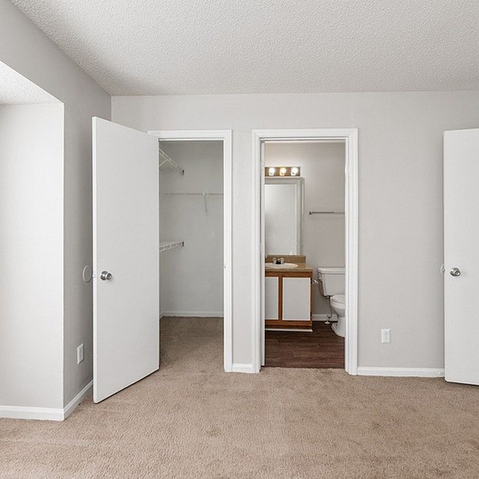 Bright and inviting bedroom with plush carpet, featuring a spacious closet and an en-suite bathroom for ultimate convenience.