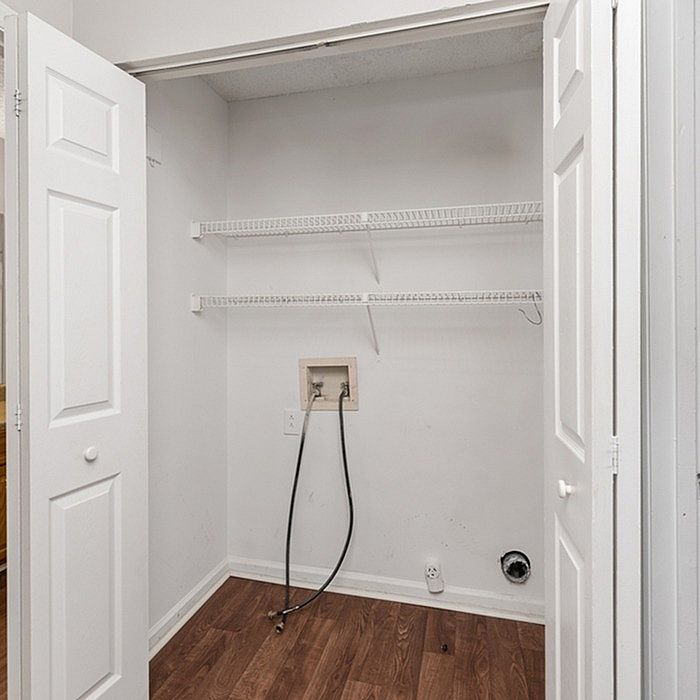 Convenient laundry closet with shelving and hookups, perfect for a modern home.