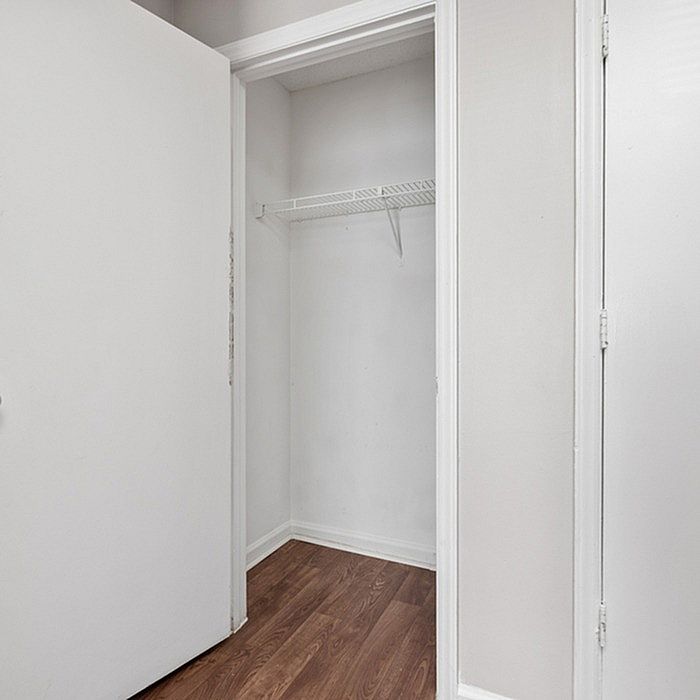 Chic apartment closet with sleek wooden flooring and ample storage space.