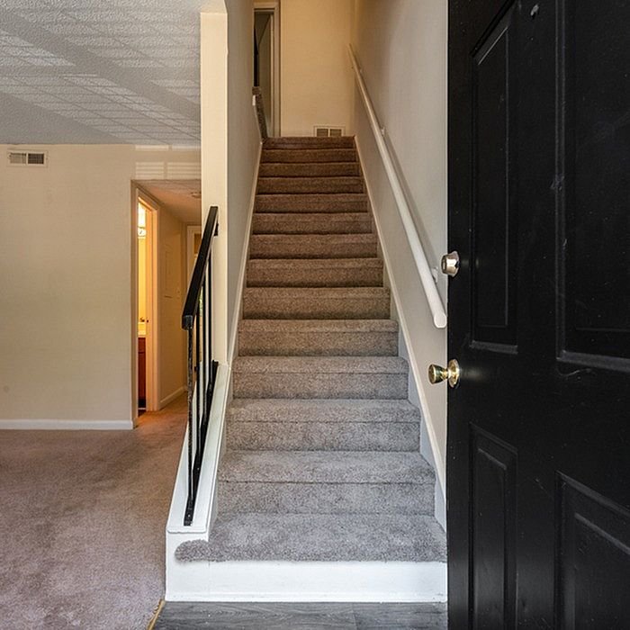 Inviting entrance with a carpeted staircase leading to upper levels, welcoming ambiance perfect for family living.